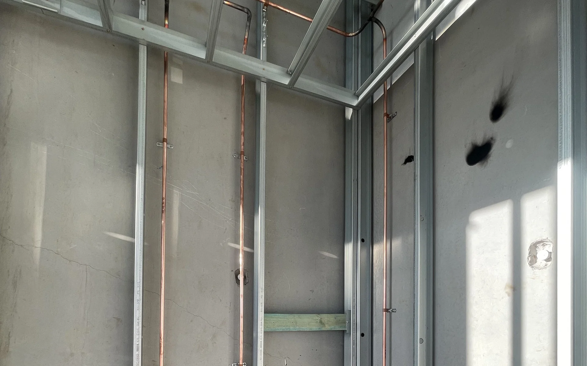 Copper water pipework installed inside a wall frame
