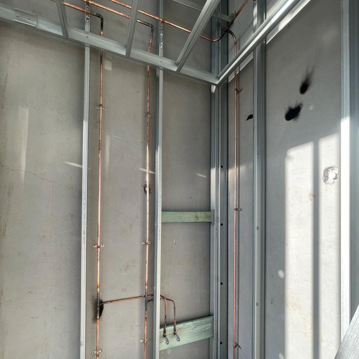Copper water risers installed in a wall ready for fixture and appliance connections