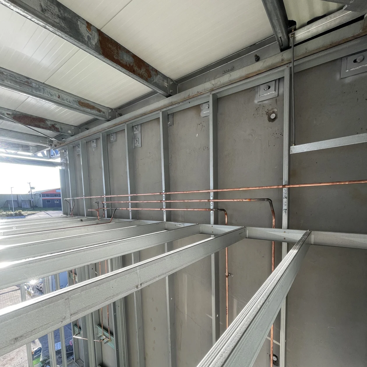 Copper pipework installed and clipped inside a wall frame