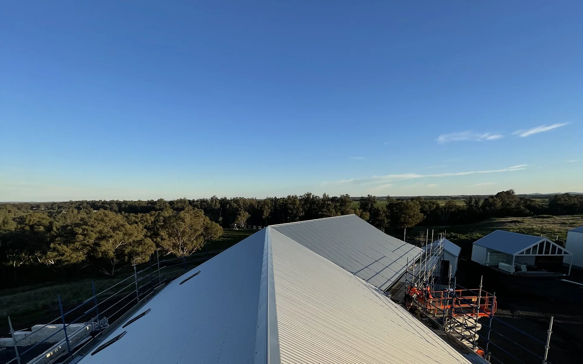 New metal roof being installed on a large building with scaffold in place