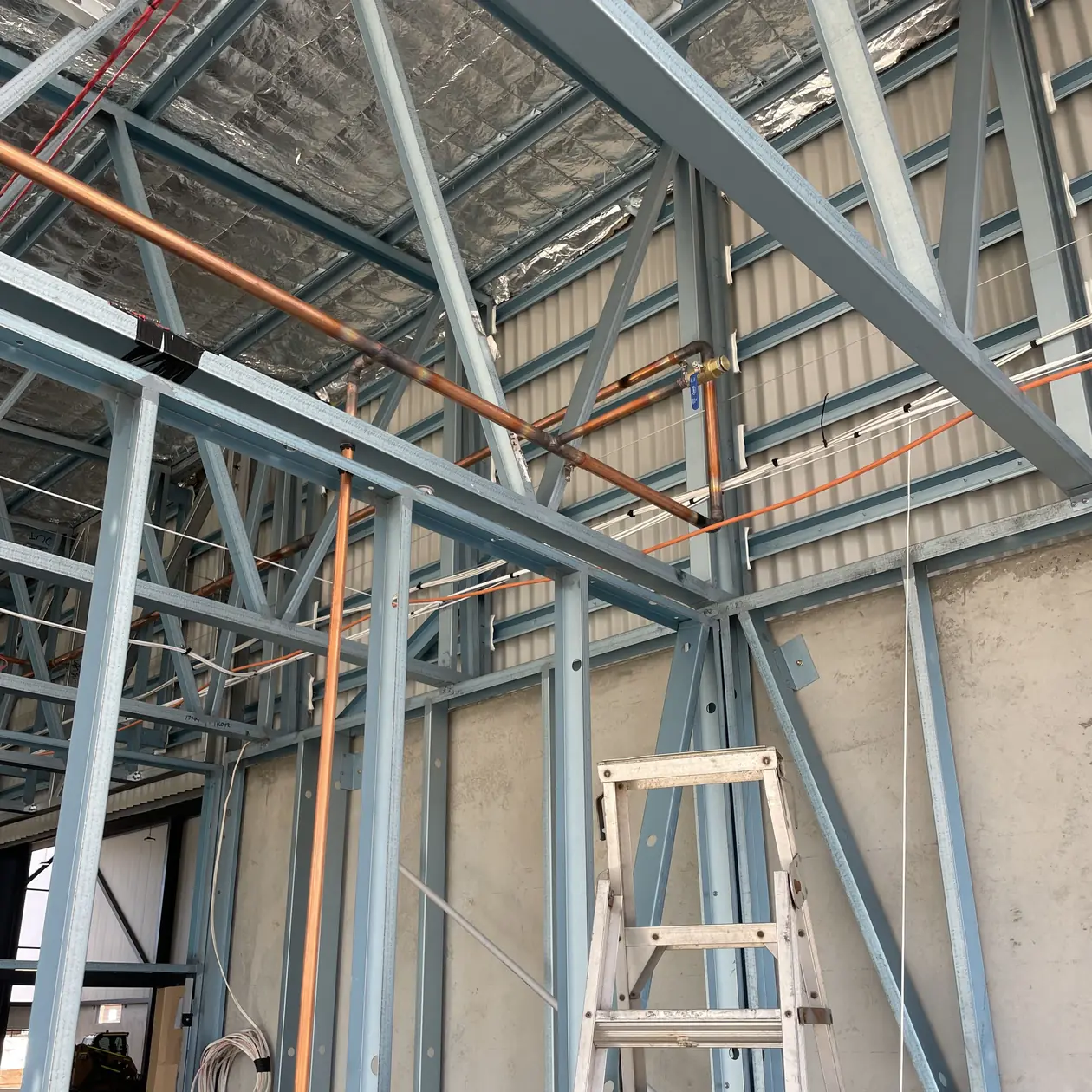 Copper pipework installed through a steel building frame