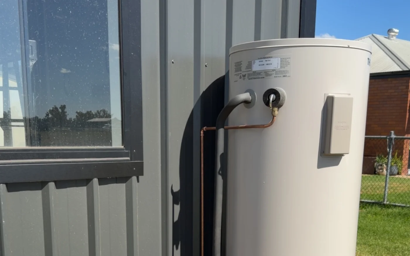 Electric storage hot water unit installed outside a building