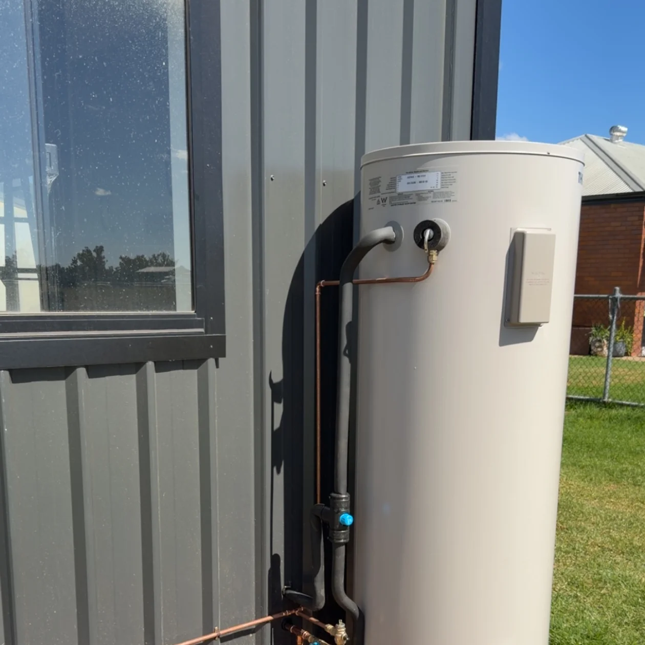Electric hot water unit installed and connected outside a building