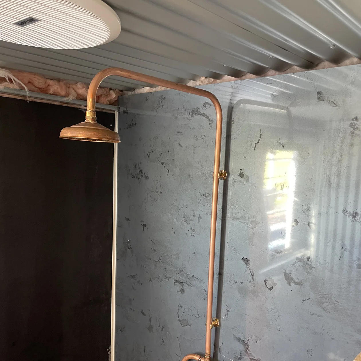 Exposed copper shower set and taps installed on a rural build