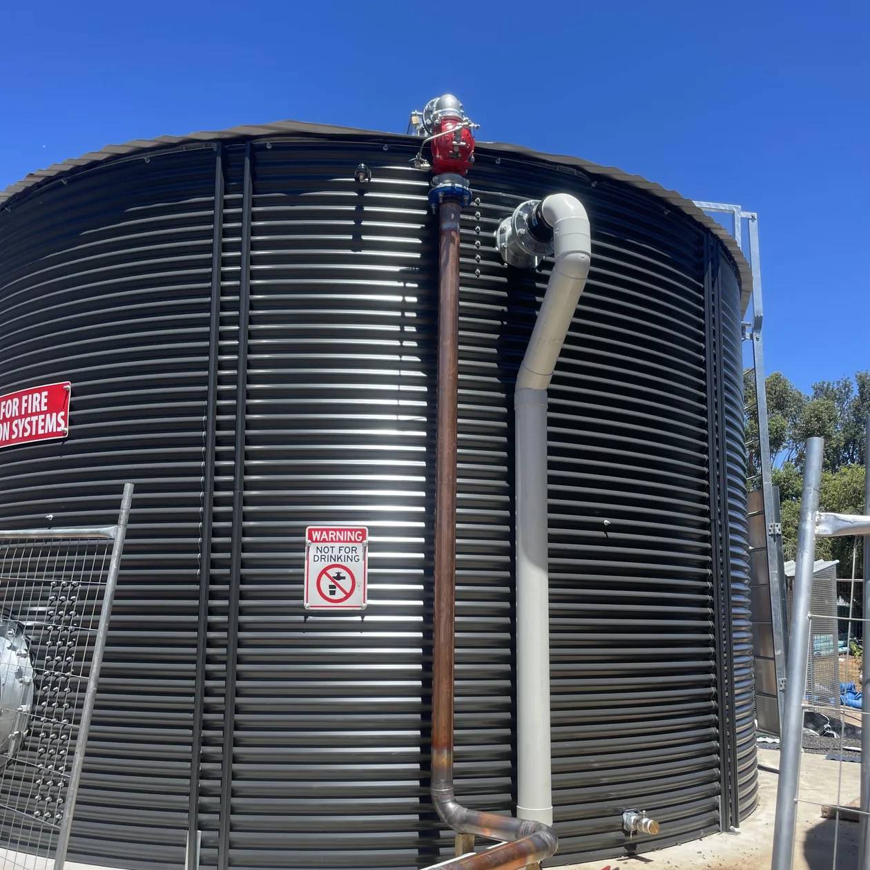 Fire water tank with copper riser and fittings installed at a commercial site