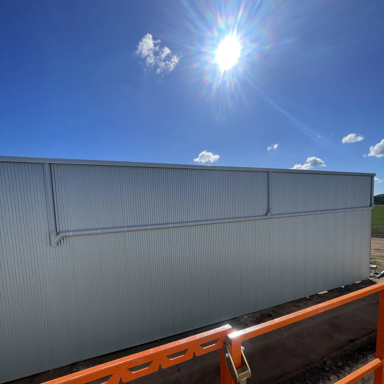 Box gutter installed along the top of a metal clad wall