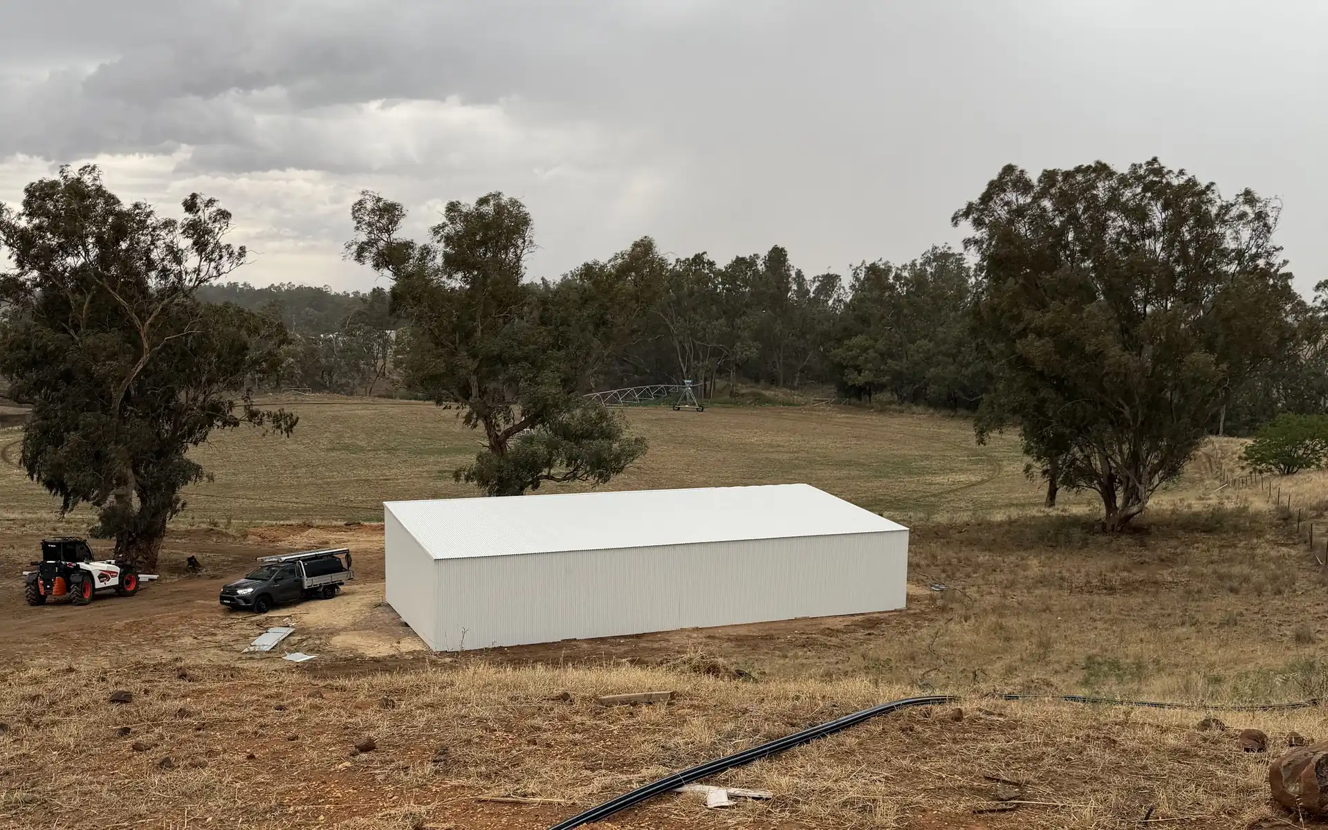 Rural building site with a work ute, excavator and new water service being run in