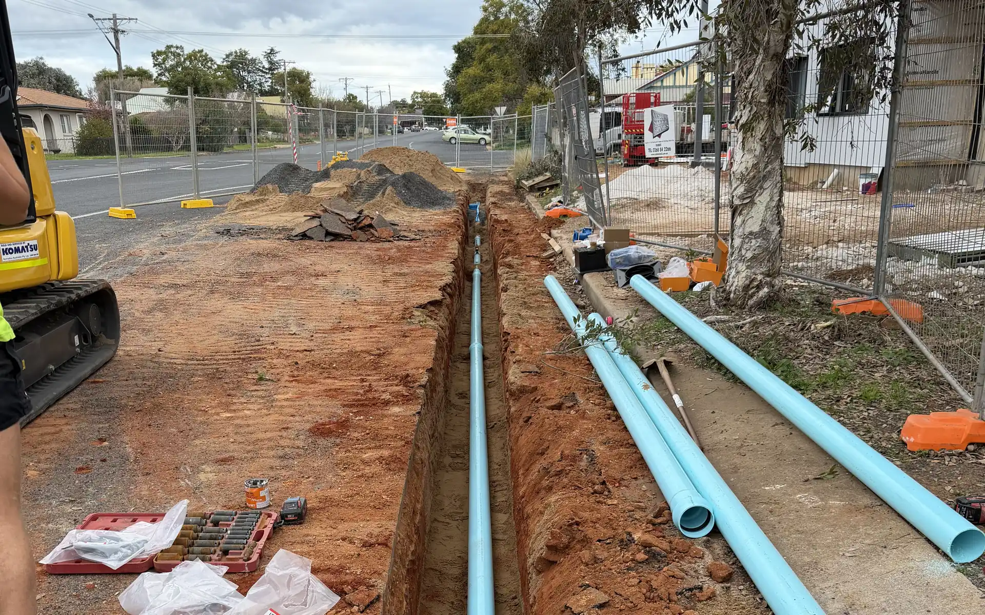 Excavation in a street with water main pipework being laid