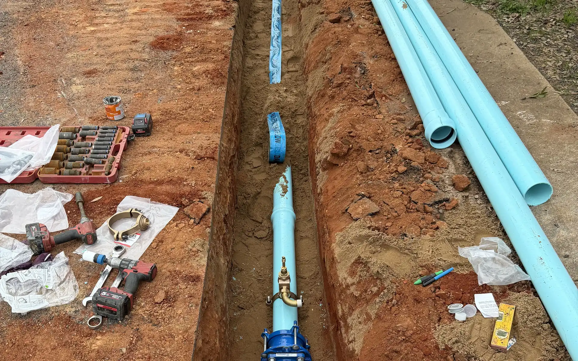 Water main and valve laid in an open trench ready for connection